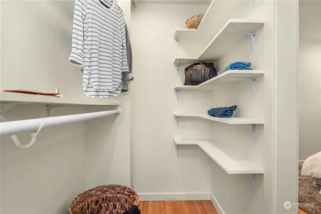 The primary walk-in closet features fantastic storage options.
