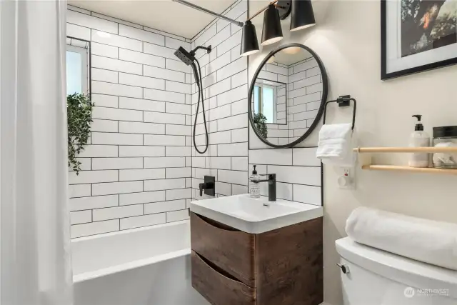 The main bath is also wonderfully updated with another floating cabinet, designer fixtures and tiled surround and floors.