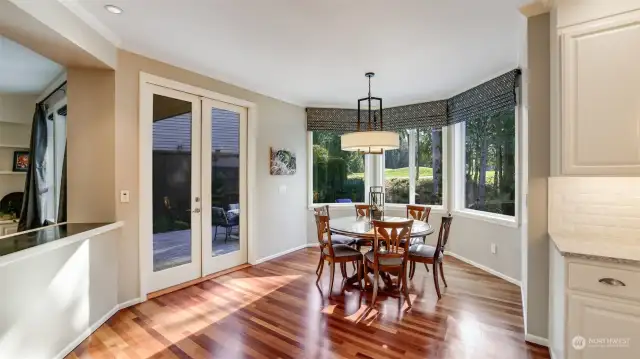 Kitchen nook infused in natural light and accented by French doors, chic chandelier, and custom solar shades.