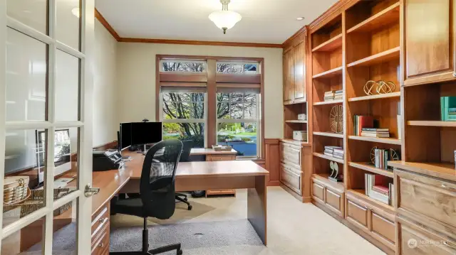 Main floor den with handsome custom built-ins, French doors, and dual work spaces.