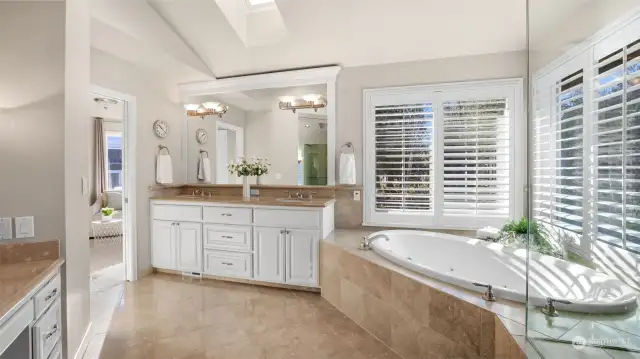 Dual vanities, wood wrapped mirror and plantation shutters highlighted by a skylight. So much light!