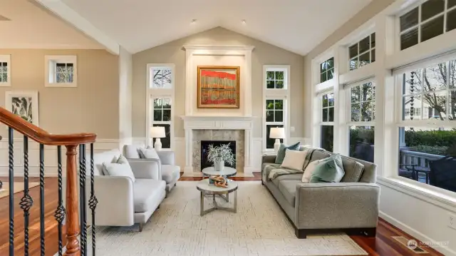 The formal living space features a marble tile surround gas fireplace with unique wood mantle detailing and an incredible wall of windows!