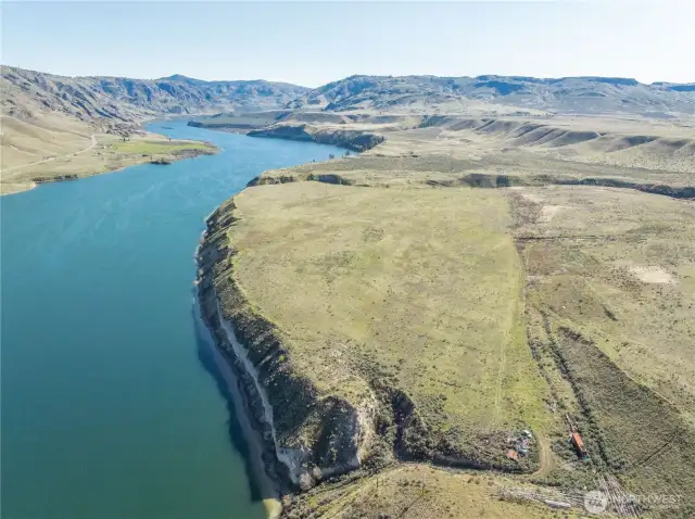 Photo shows access road to river and well is located approximately lower right corner of photo near the storage container.