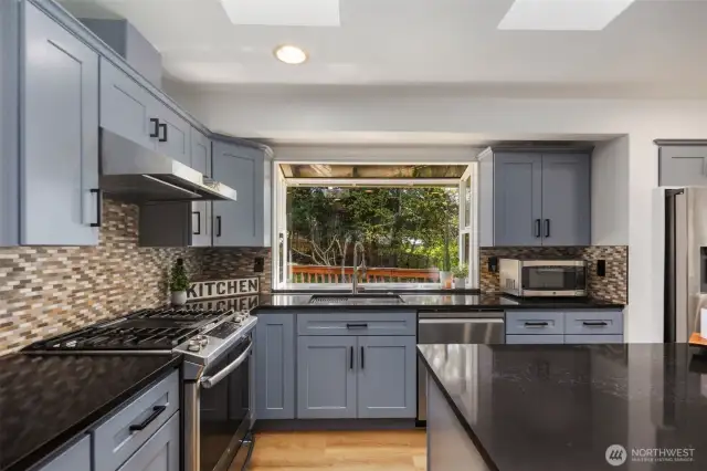 The chef's kitchen is a dream, featuring a generous island, gas cooktop with hood!