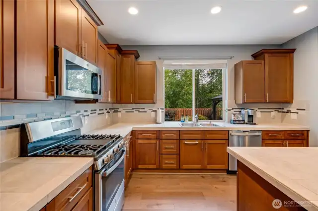 Gas range with griddle. Large kitchen window takes view of the landscaped yard and greenbelt.