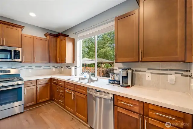 Upper cabinet on the right side of the range houses pull out spice caddies. A great accessory for storing every spice. Note the size of the kitchen window and full height backsplash. Lower cabinets have pull out shelving in multiple locations.