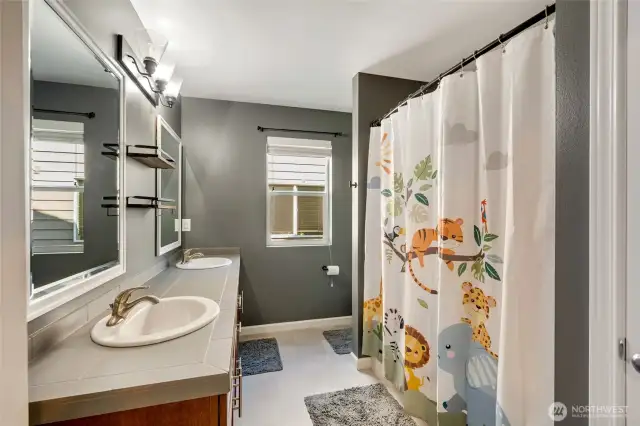 Hall full bathroom with double vanity and bathtub/shower.