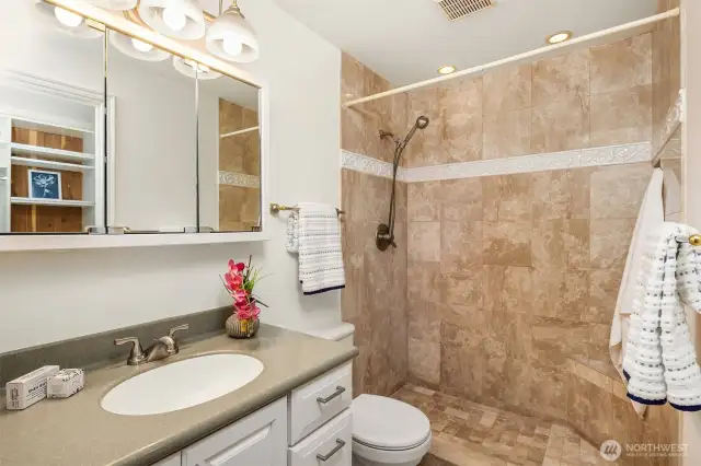 Primary shower with convenient hand-held shower and corner seat