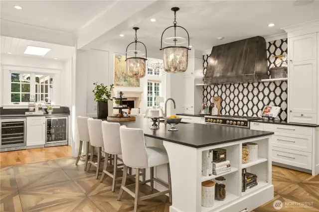 Spacious kitchen features top of the line cooking and refrigeration: 48” Big Chill range, separate wall oven and microwave, center island with sink, Subzero refrigerator, and beverage center with wine fridge