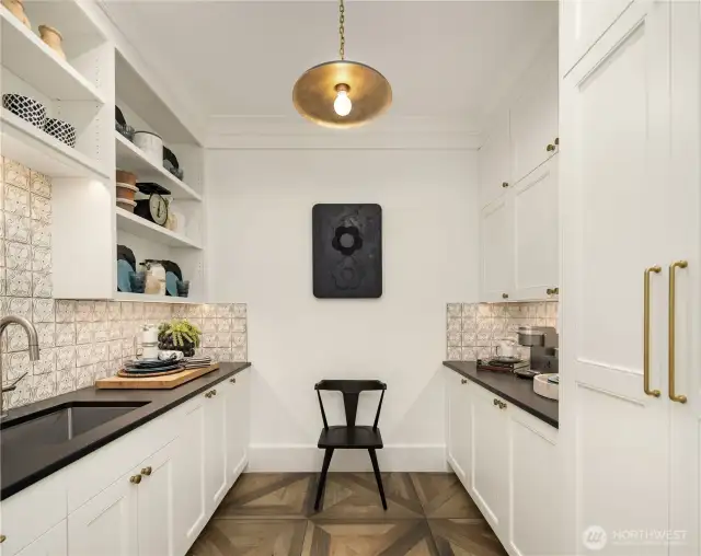 The scullery has Tabarka’s hand painted Polanco tile in off-white, Indian Stone honed granite countertops, plentiful storage, and a second sink and dishwasher