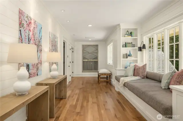 Gracious upstairs hallway with built-in window seat reading nook and bookshelves