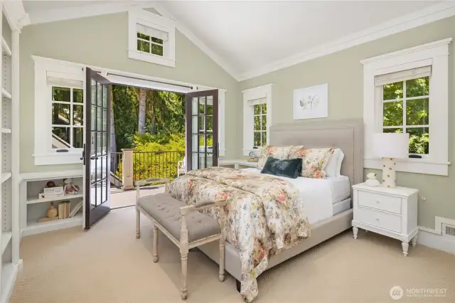 Western bedroom has a vaulted ceiling, built in bookcases and French doors to an upper porch