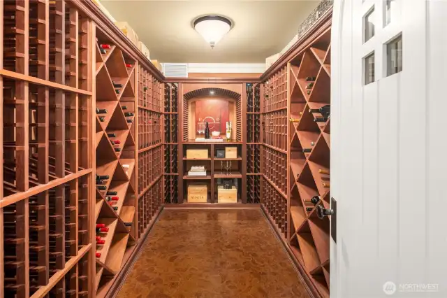 Temperature controlled wine cellar with arched door entry, cork floor and built-in wine racks