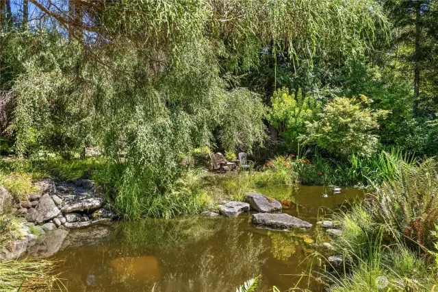 Lushly landscaped to complement the natural setting with sweeping flagstone terraces that overlook the waterfall and ponds