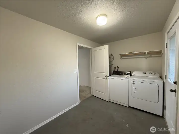 Laundry room located in the garage, offering lots of extra storage space