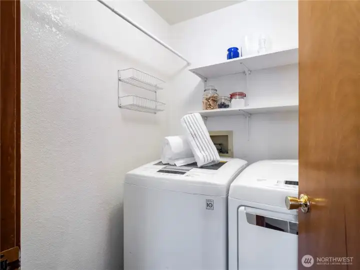 The laundry room is conveniently located by the kitchen and close to the garage exit.