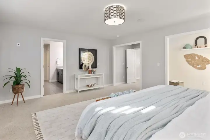 Primary bed with view to hallway, bath, and nook.