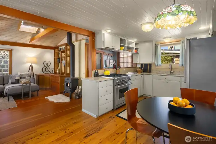 The kitchen and living room share a natural flow, anchored by a cast-iron wood stove that makes the whole main level feel warm and inviting on Pacific Northwest evenings.