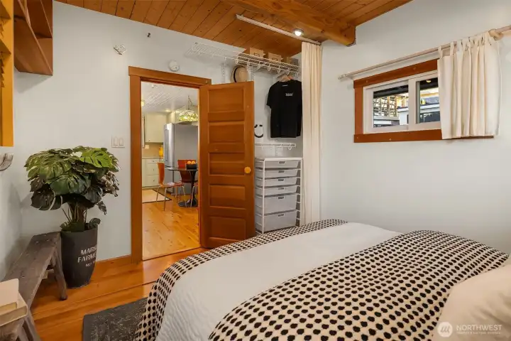 A second angle of the main bedroom reveals its practical layout, with a closet alcove and easy access to the kitchen and main living areas.