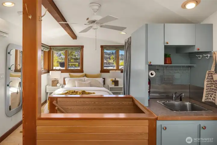 The upper level bonus room creates a complete private suite: primary bedroom with lake views, a convenient sink, studio space and its own quiet sense of place, removed from the main living areas.