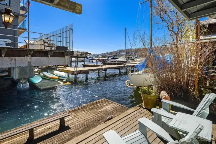Step off the living room onto your private dock-level deck, where Adirondack chairs face the marina and Lake Union stretches out in front of you on a sunny Seattle afternoon.