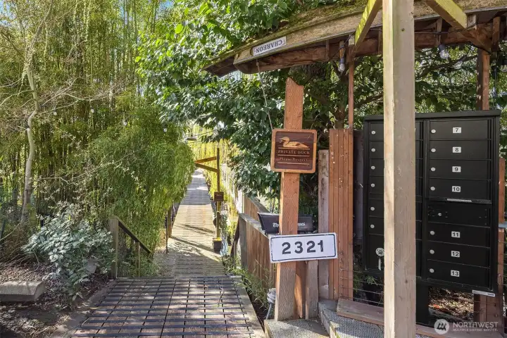 The moorage entrance at The Willow Dock sets the scene: a pergola, mature trees, and a row of mailboxes, covered by an upside down canoe, mark the beginning of something truly different from a standard Seattle address.