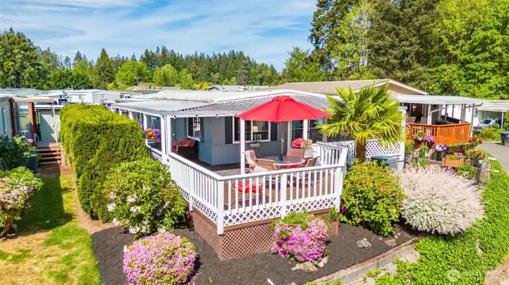 Beautifully landscaped grounds with colorful blooms, raised garden beds, and a charming palm tree create a warm Pacific Northwest coastal vibe. Beautifully landscaped grounds with colorful blooms, raised garden beds, and a charming palm tree create a warm Pacific Northwest coastal vibe.