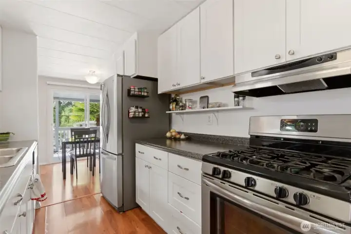 Beautifully updated kitchen features shaker-style cabinetry, stainless steel appliances, solid surface countertops, and a propane range designed for everyday cooking and entertaining. Beautifully updated kitchen features shaker-style cabinetry, stainless steel appliances, solid surface countertops, and a propane range designed for everyday cooking and entertaining.