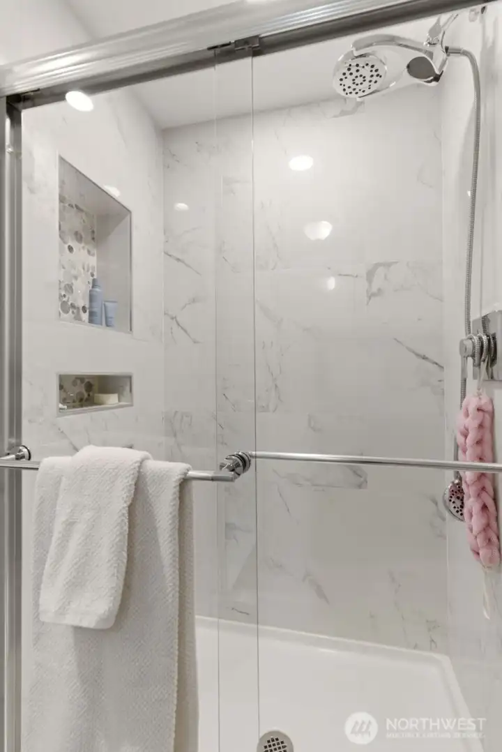 Elegant walk-in shower features full tile surround, glass doors, and custom tiled niches for bath essentials with a clean, upscale finish. Elegant walk-in shower features full tile surround, glass doors, and custom tiled niches for bath essentials with a clean, upscale finish.
