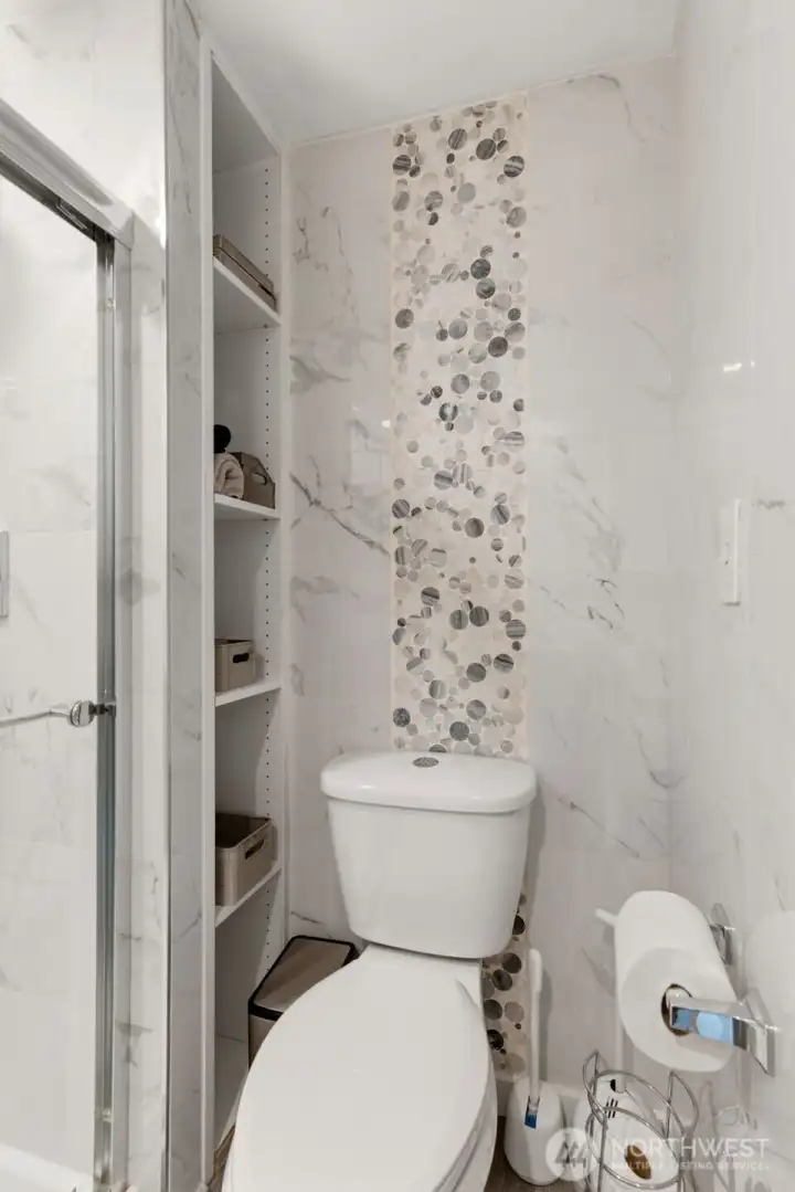 Owner’s Suite bathroom features floor-to-ceiling tile, a new toilet, stylish tile accents, and a built-in shelving alcove for added storage. Owner’s Suite bathroom features floor-to-ceiling tile, a new toilet, stylish tile accents, and a built-in shelving alcove for added storage.