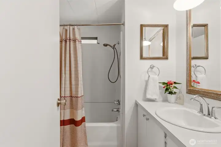 Full guest bathroom with extended vanity and shower-tub combo provides added comfort and functionality for guests. Full guest bathroom with extended vanity and shower-tub combo provides added comfort and functionality for guests.