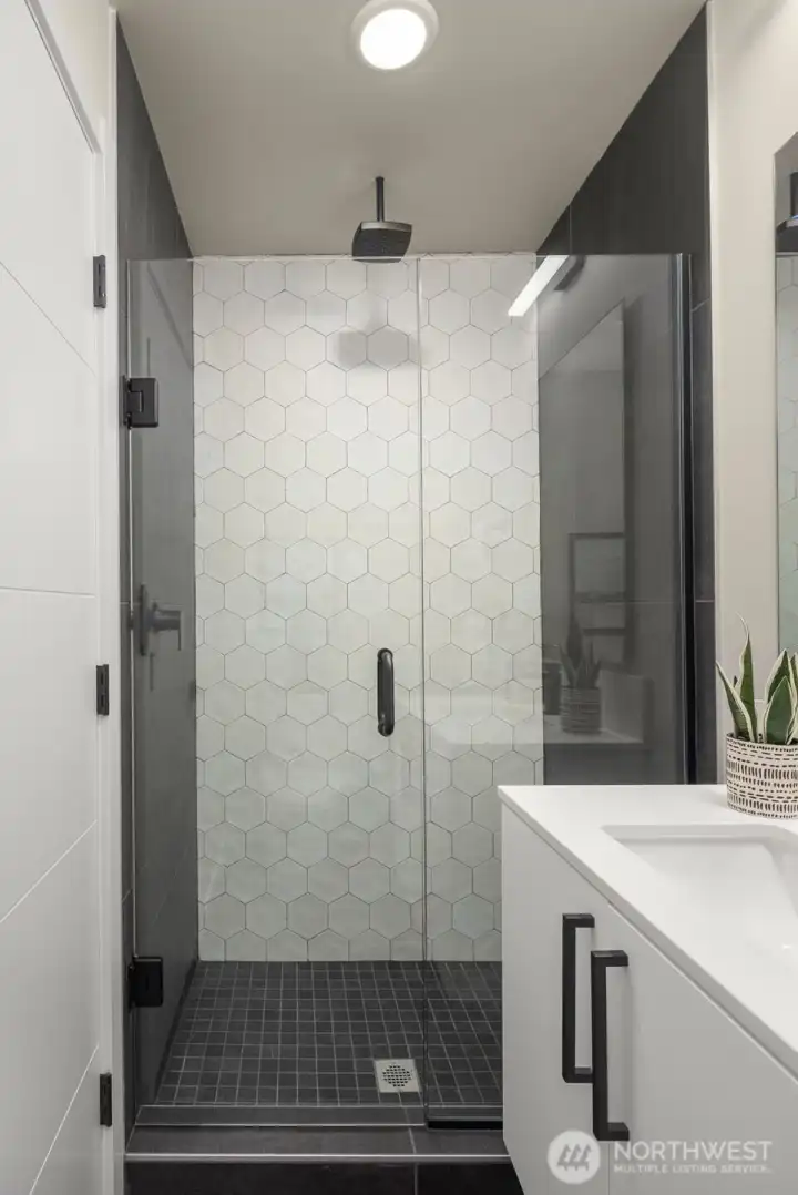 Crisp geometric tile and sleek finishes create a bathroom that feels both sculptural and serene—a modern backdrop for your morning ritual.