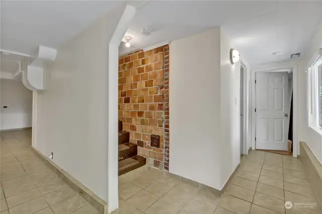View of stairs and original brick detail. To the right is one bedroom and one bonus room. To the left a bedroom, kitchenette and 3/4 bath. Entrance just behind this shot.