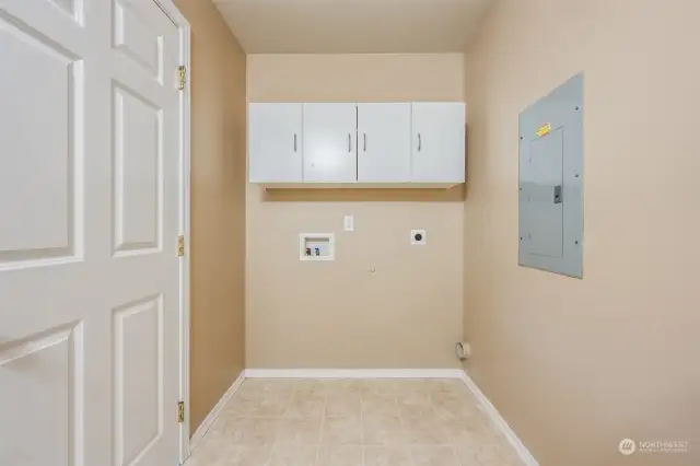 Laundry space with upper cabinets for storage. Bring your washer and dryer for this dedicated space.