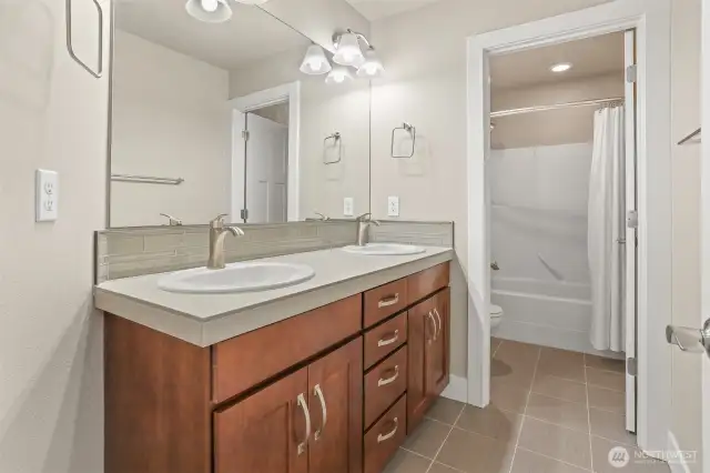 Both full bathrooms on the upper level have dual vanities. This is the additional bath located on upper level.