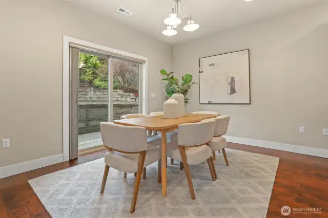 Dining area and glass sliders which open to a backyard patio.