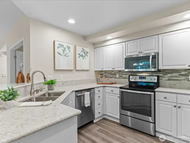 Kitchen has newer quartz counters and stainless steel appliances