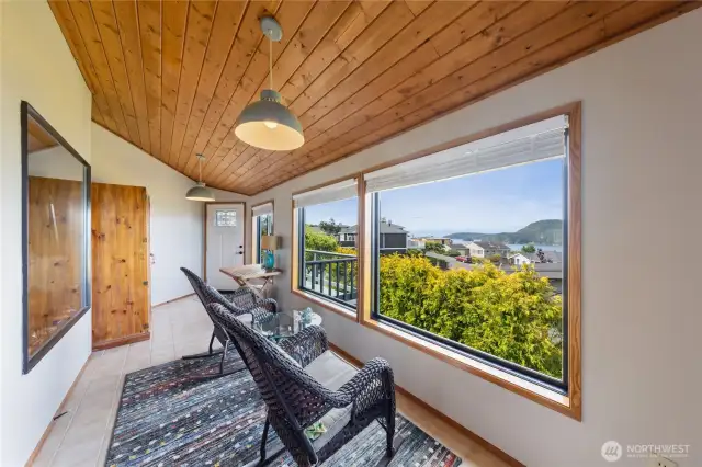 Enclosed sunroom with warm, wood ceilings to relax and enjoy the gorgeous views.