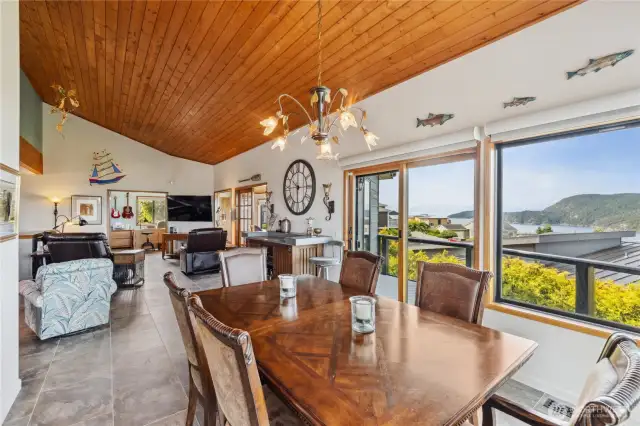 Another view of the dining and living spaces showing off the views of Burrows Bay and the Olympic Mountains.