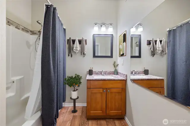 The hall bathroom includes a full shower-tub combination, large mirror and a vanity sink.
