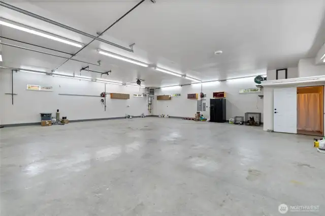 The expansive 40' x 42' shop, located beneath the living space, is a dream for hobbyists and professionals alike. It includes a 3/4 bathroom with a shower, a powerful 5 HP Quincy air compressor, and an oversized 150,000 BTU propane heater. A 4" exhaust port is built into the wall—ideal for woodworking or use with a blast cabinet. The custom concrete slab is built to last, featuring 23 chain pots, heavy reinforcement with Sch. 40 half-inch rebar spaced 2 feet on center and epoxied into the footing, Propex semi-industrial fibers, and a six-sack mix poured to a 6-inch thickness, plus R38 Insulation in garage/shop ceiling.