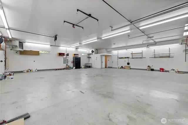 Piping has been installed throughout the shop to support the air compressor system, ensuring efficient air distribution. To the left, the 150,000 BTU propane heater keeps the workspace warm year-round. In the back right corner, you'll find a bathroom with a shower. An additional entrance door, to the right of the bathroom door, offers convenient access to the carport. This versatile space is designed for function and flexibility—offering endless possibilities for work, storage, or creative projects.
