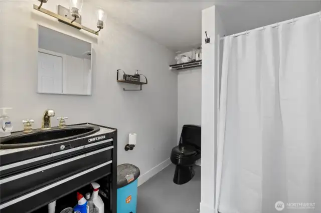 Shop bath with custom toolbox vanity and a shower.