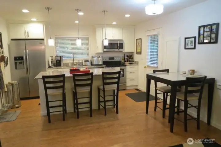 Totally remodeled kitchen with door to new covered outdoor living space deck.  SS appliances, granite counters, eating island.