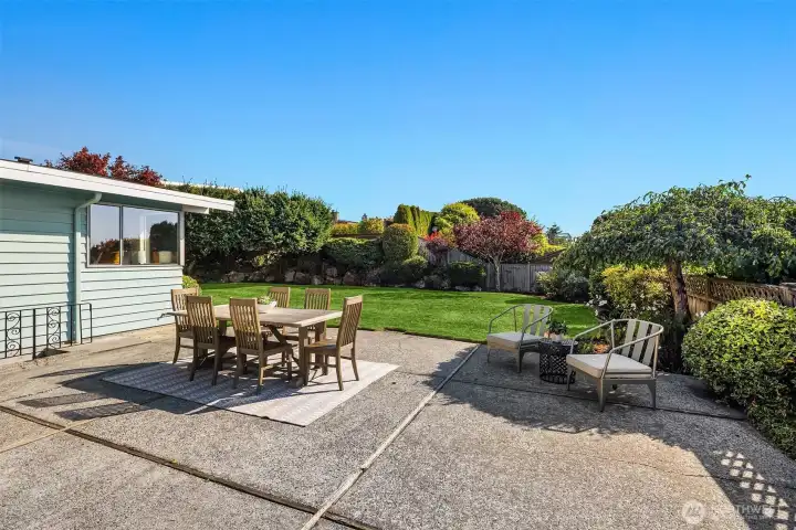 Big open patio space with flat level backyard and grass.