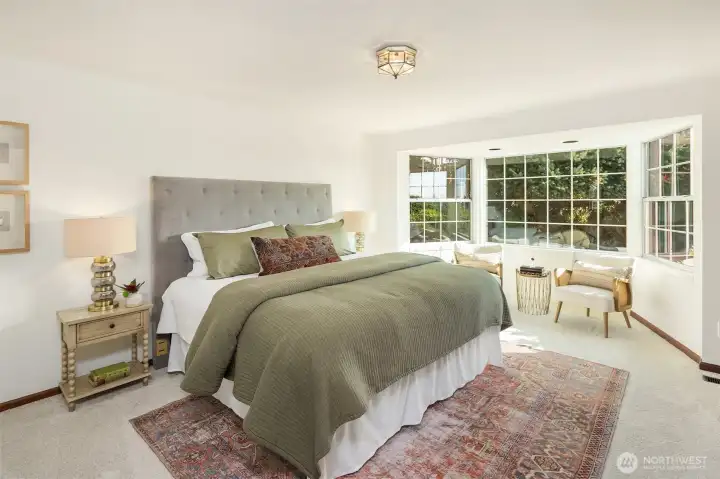 Spacious primary bedroom on the main floor with a large bay window looking into the private back yard. Space for a king size bed with plenty of room to spare.