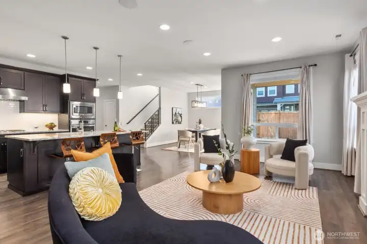 Living room with kitchen and dining room in the background.