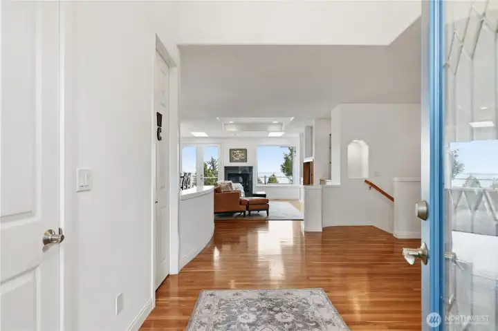 Entering the home.  Gleaming hardwood floors.  Coat closet and powder room doors on the left.