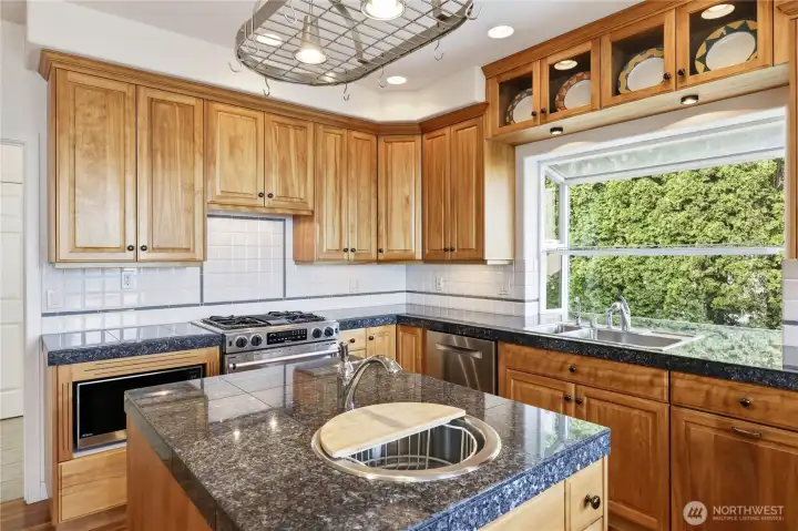 Handy sink in the center island, greenhouse window, and prep space and cabinets galore.