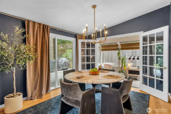 Dining room with French doors, moody lighting & an easy flow for indoor/outdoor entertaining.
